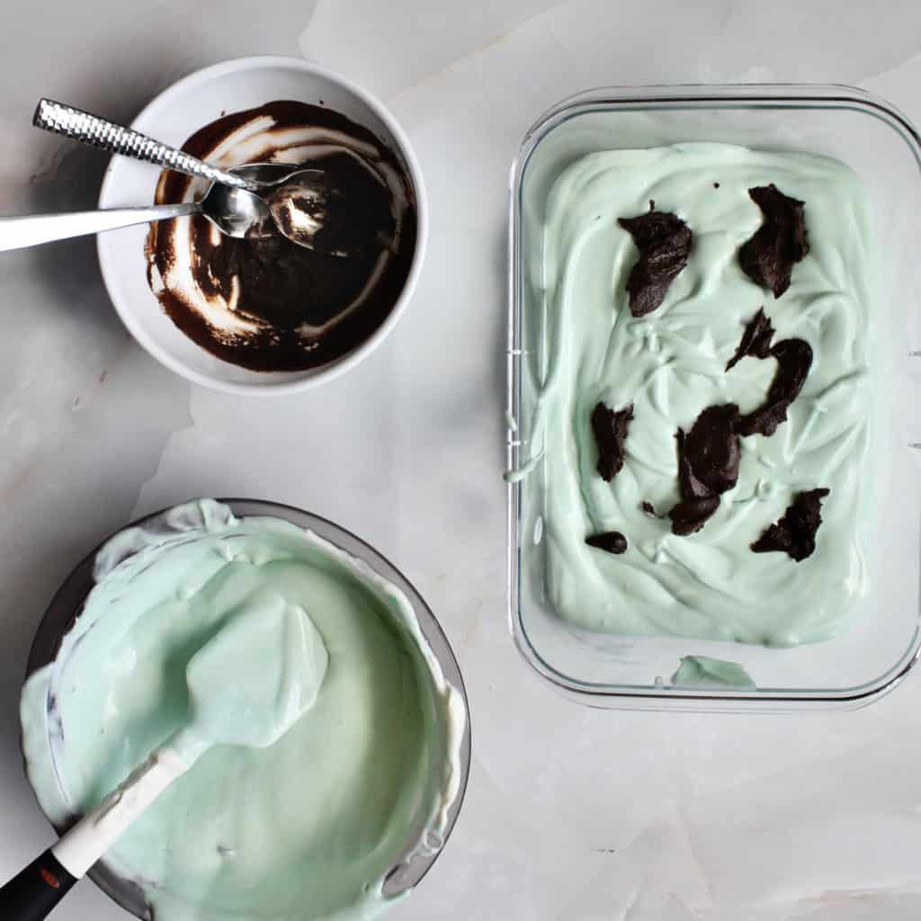 Container of no churn mint chocolate ice cream with ganache