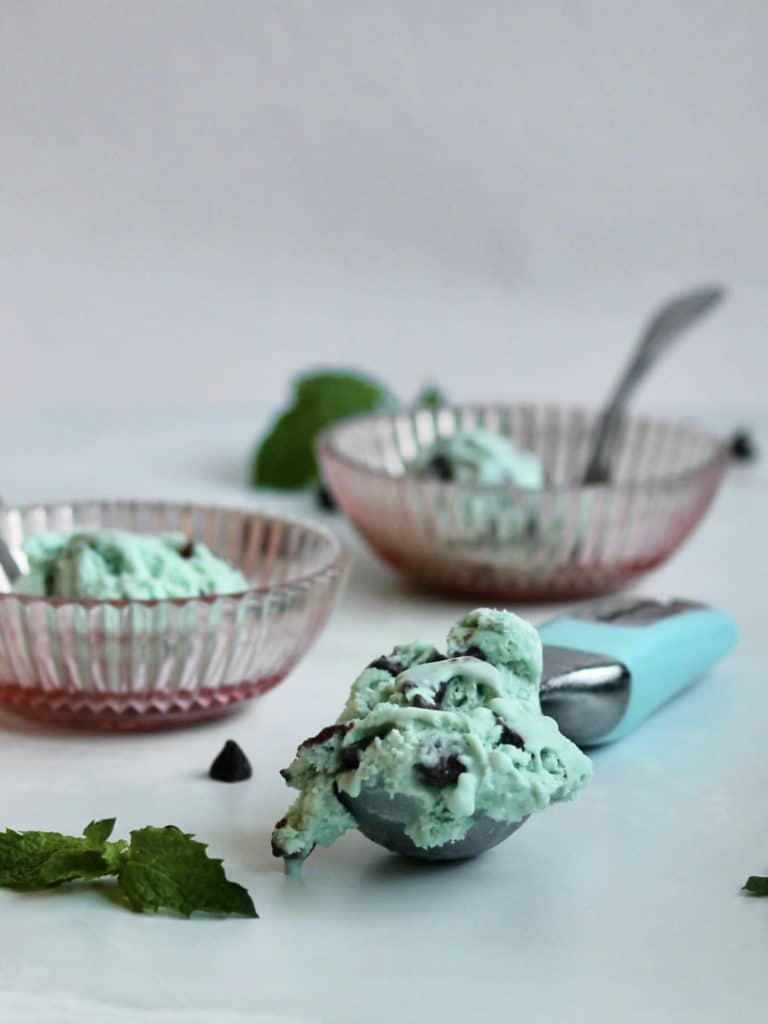 Bowls and scoop of no churn mint chocolate ice cream