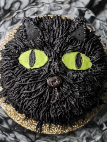 Overhead image of a black cat cake, made from black cocoa powder.