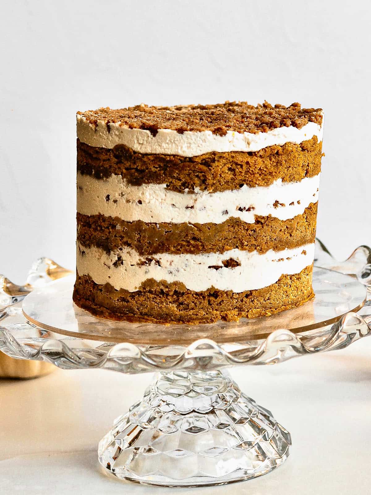 Pumpkin chai cake on a glass cake stand.