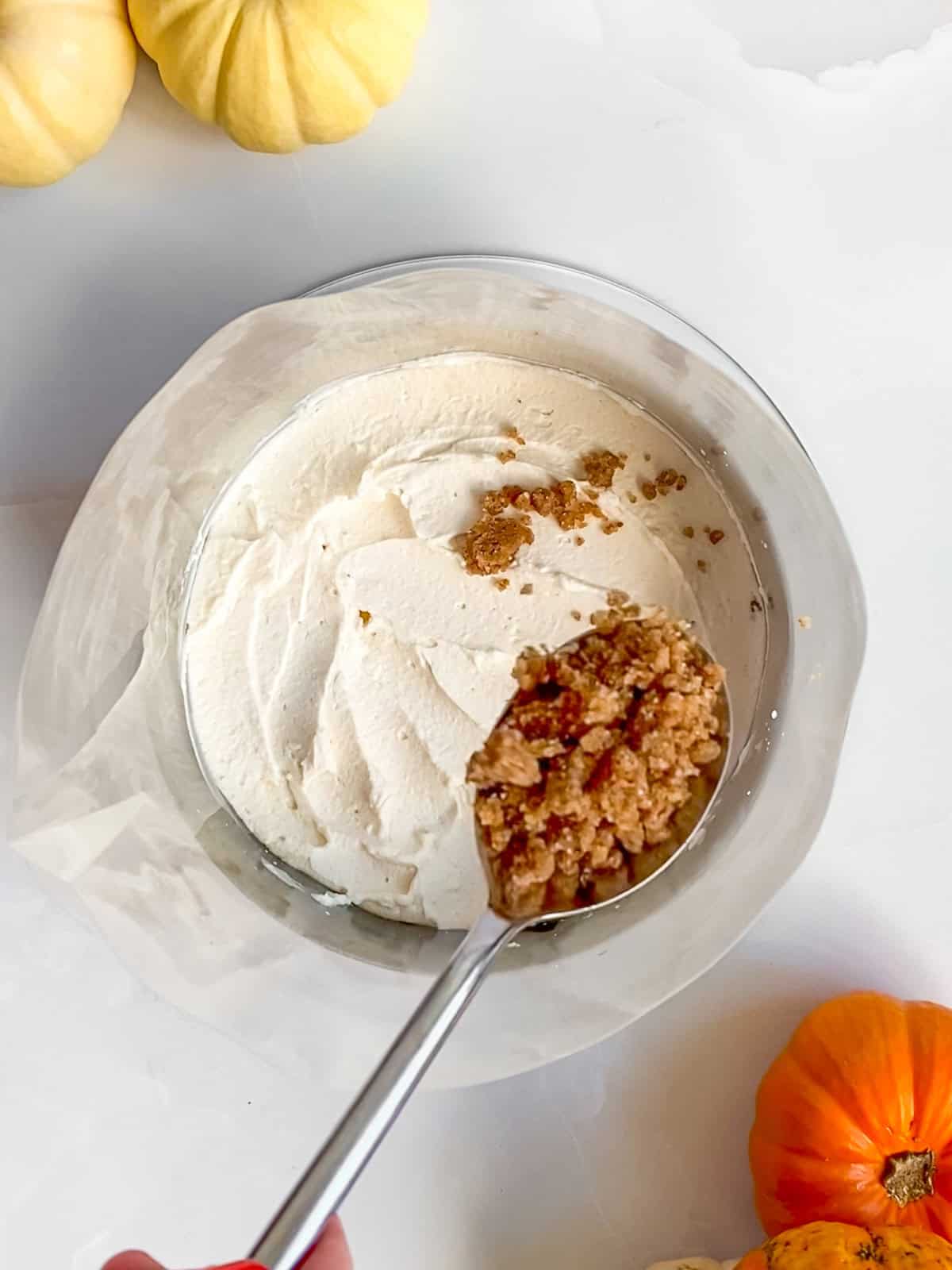 Sprinkling Biscoff chai crumb over the frosting layer