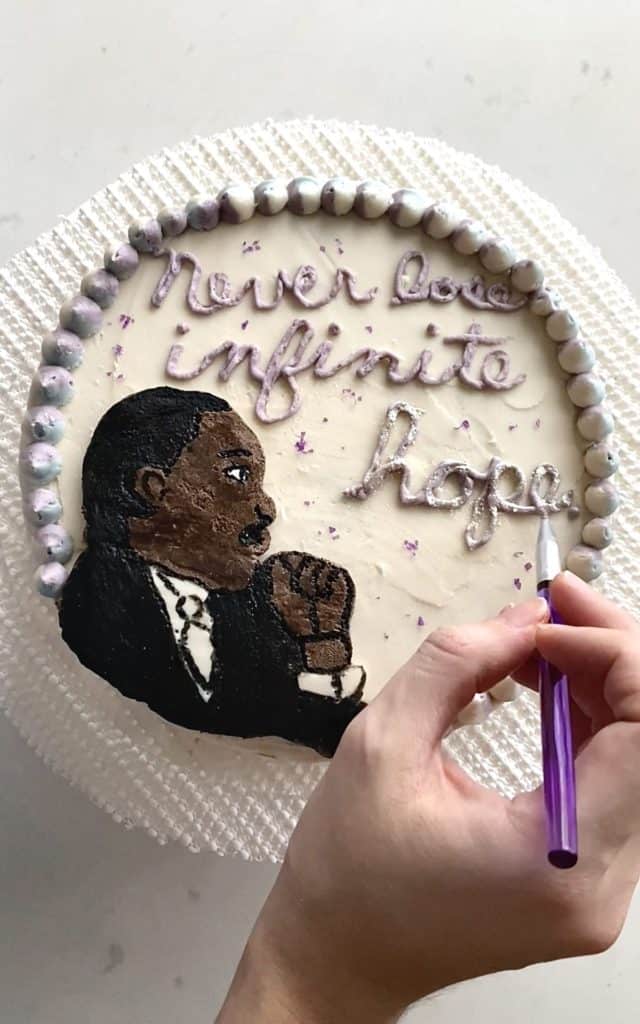 Adding edible sparkly flakes to Martin Luther King Jr. Cake