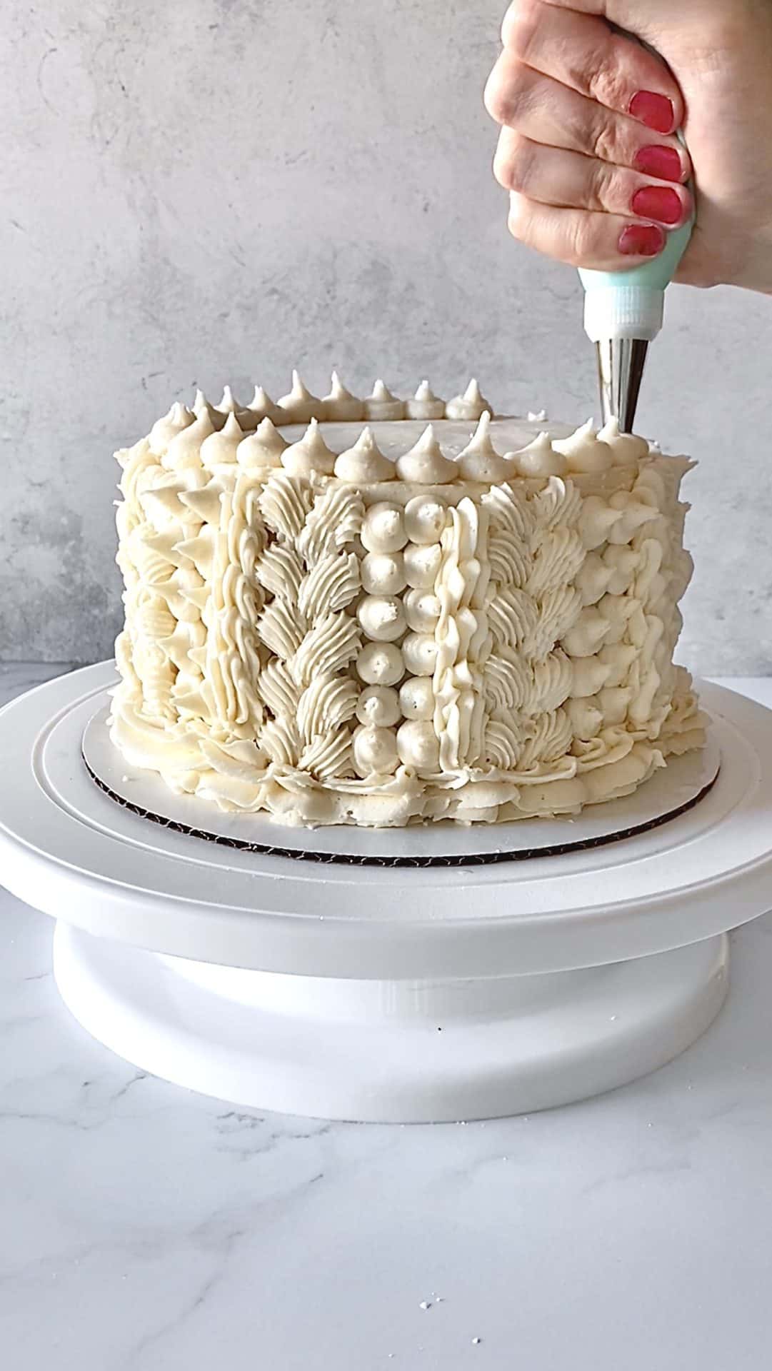 piping dots on top of textured buttercream cake