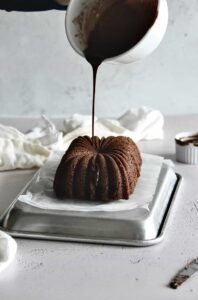 pouring nutella ganache onto loaf cake