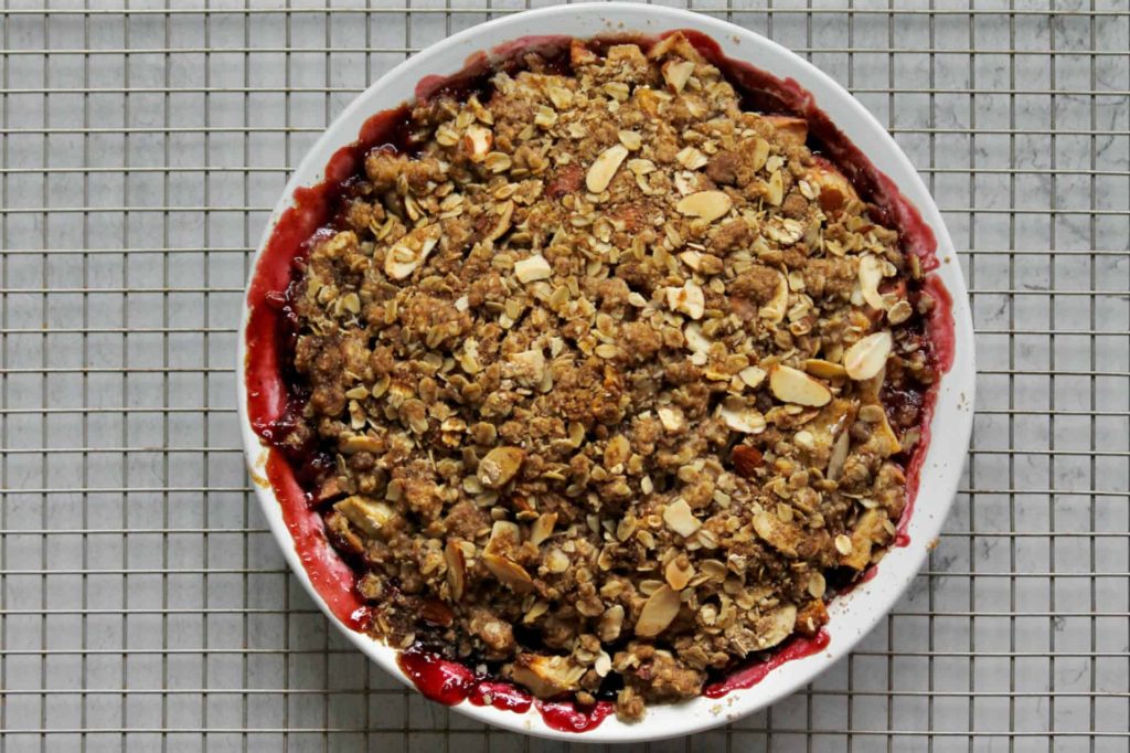 overhead image of an apple cherry crisp made with frozen cherries, cooling on a baking rack