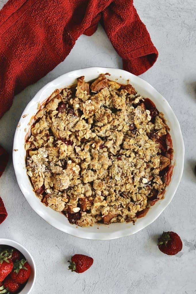 image of baked fruity crumble with strawberries and a red towel surrounding it