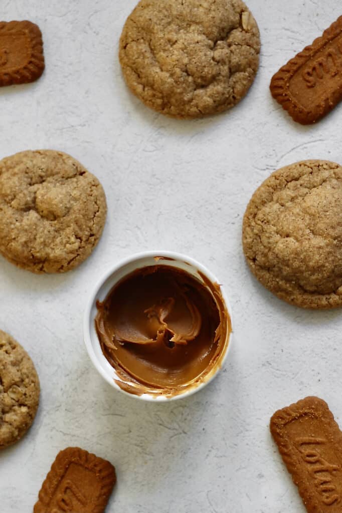 overhead image of baked Biscoff butter cookies and a ramekin with the spread inside it