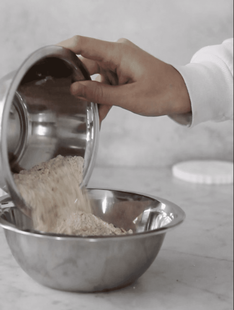 Pouring oat flour into mixing bowl with all-purpose flour
