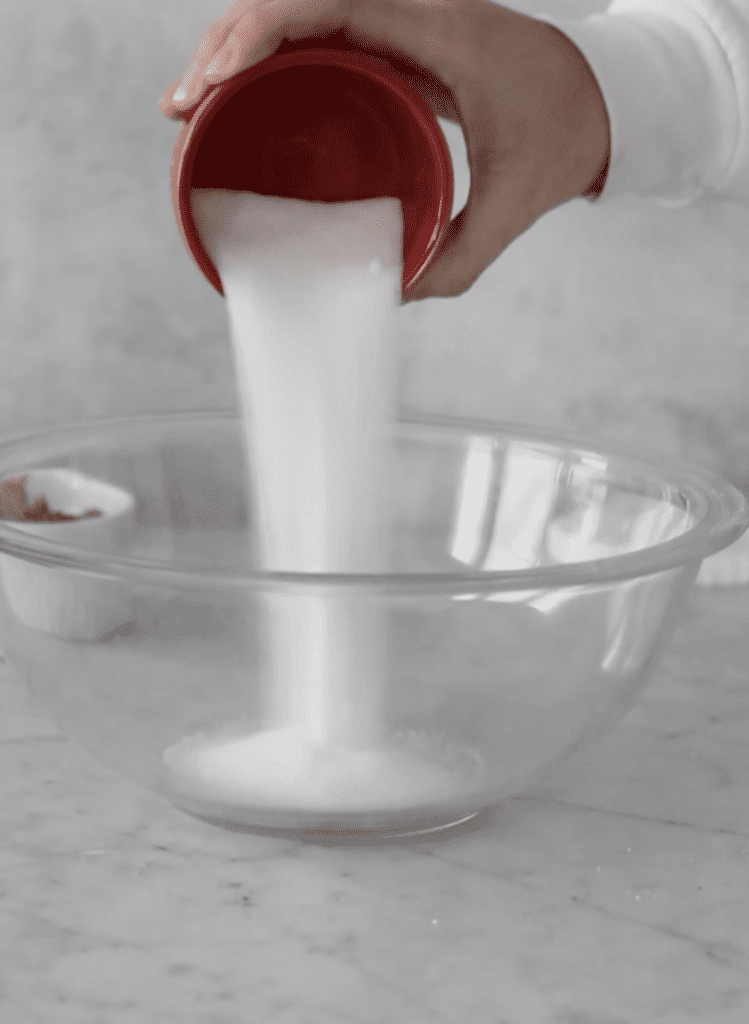Pouring granulated sugar into mixing bowl