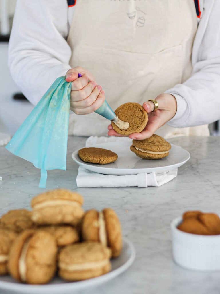 Piping frosting onto Biscoff sandwich cookies.