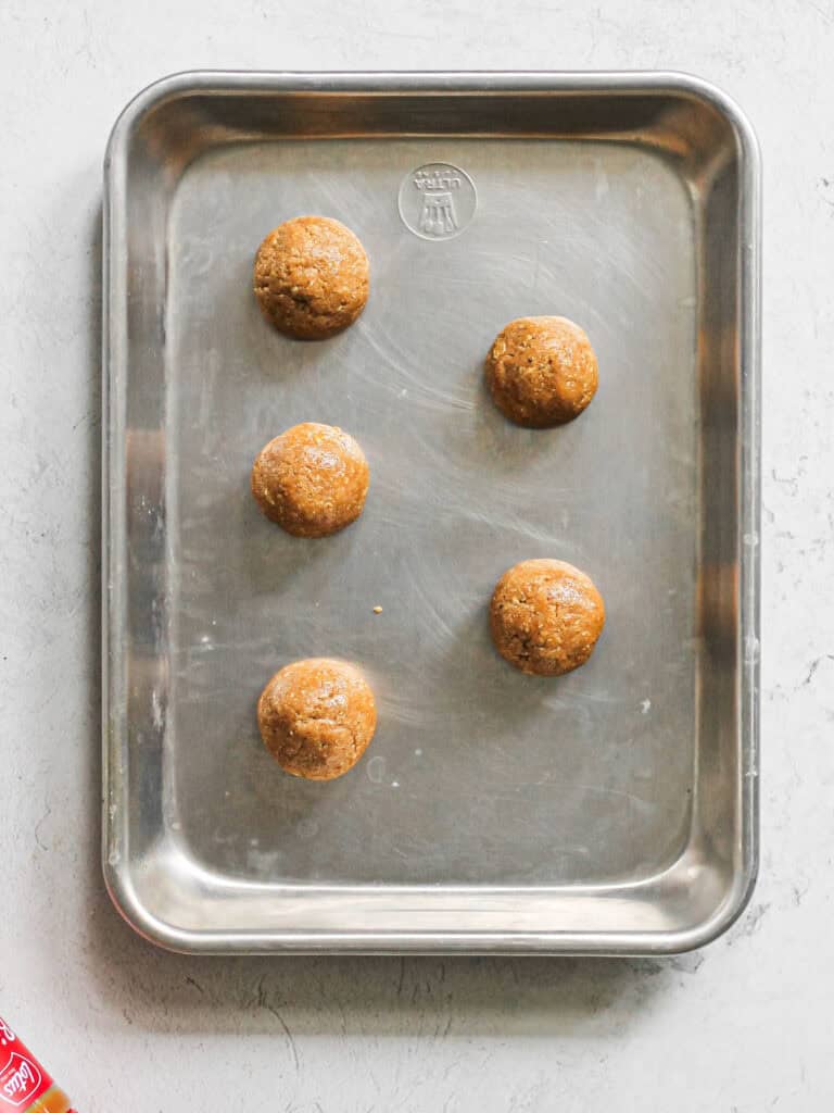 Biscoff Sandwich Cookie dough balls on baking sheet.