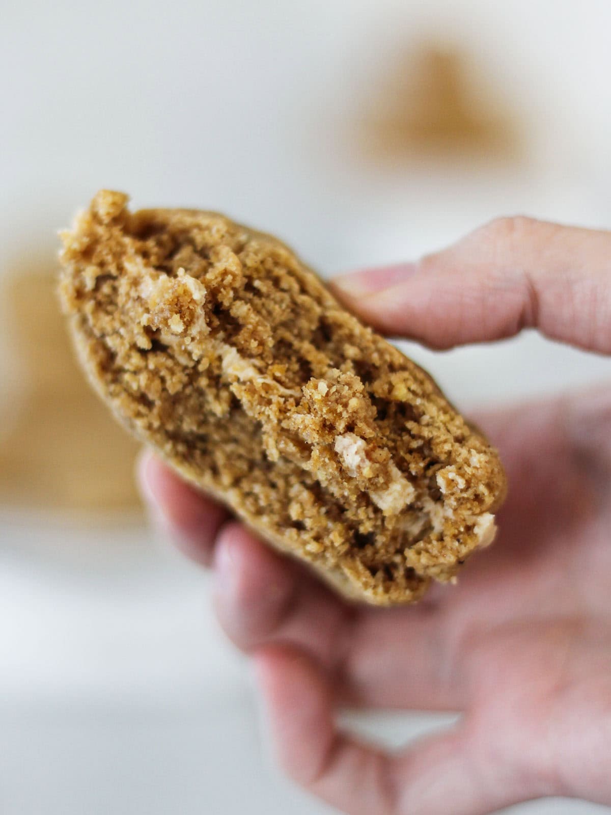 Hand holding the inside of a Biscoff sanwich cookie.