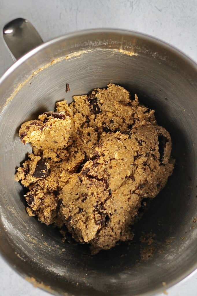mixing bowl with oat flour cookie dough and chocolate chunks in it