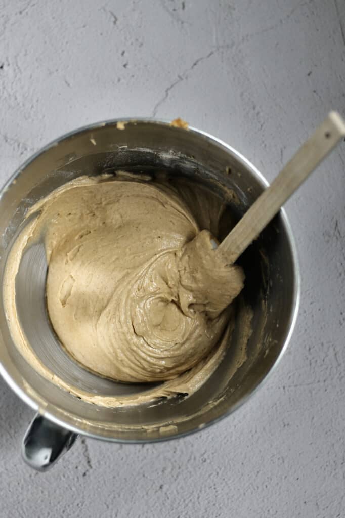 Cake batter in a mixing bowl with spatula