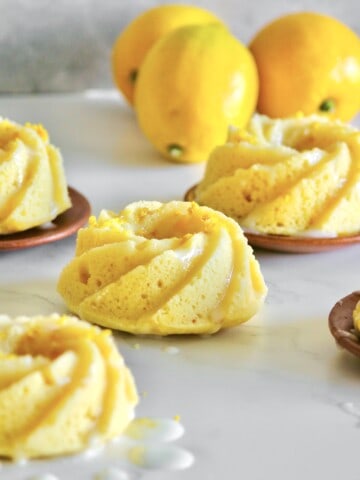 mini lemon cakes glazed with sour cream and sitting on a grey countertop