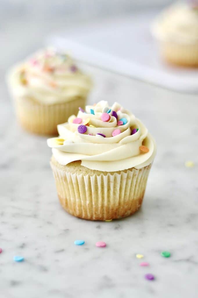 up-close images of vanilla cupcakes, decorated with confetti sprinkles