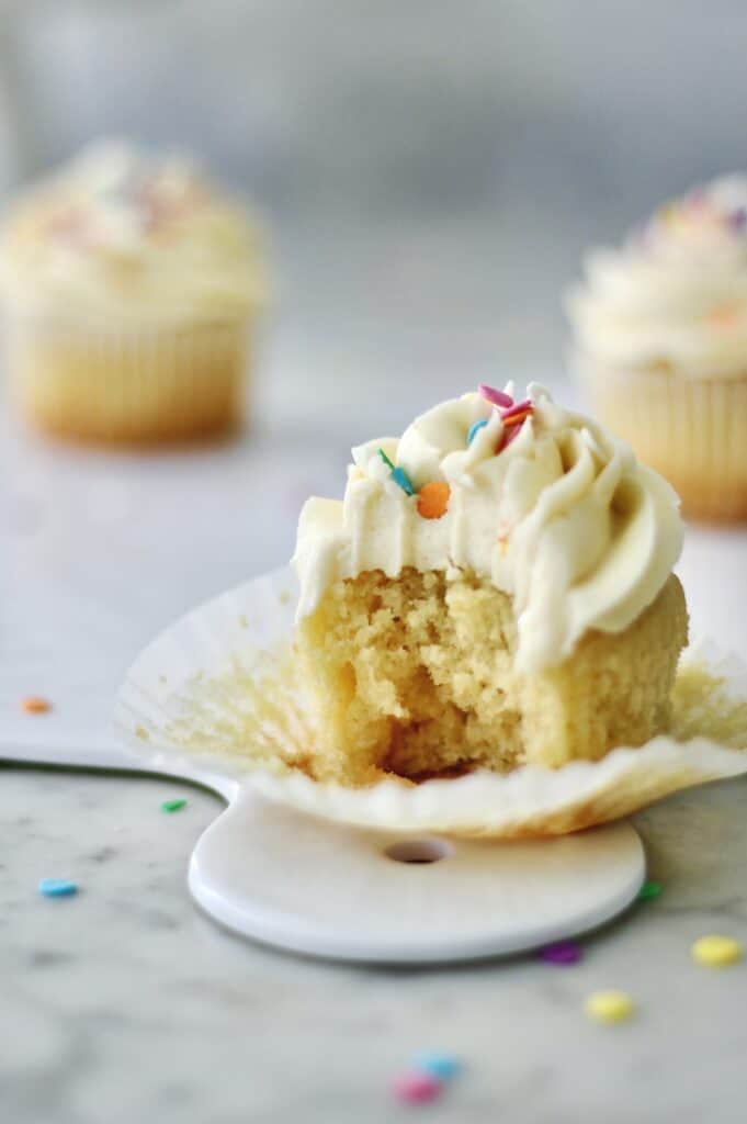 vanilla cupcake with a bite missing from it 