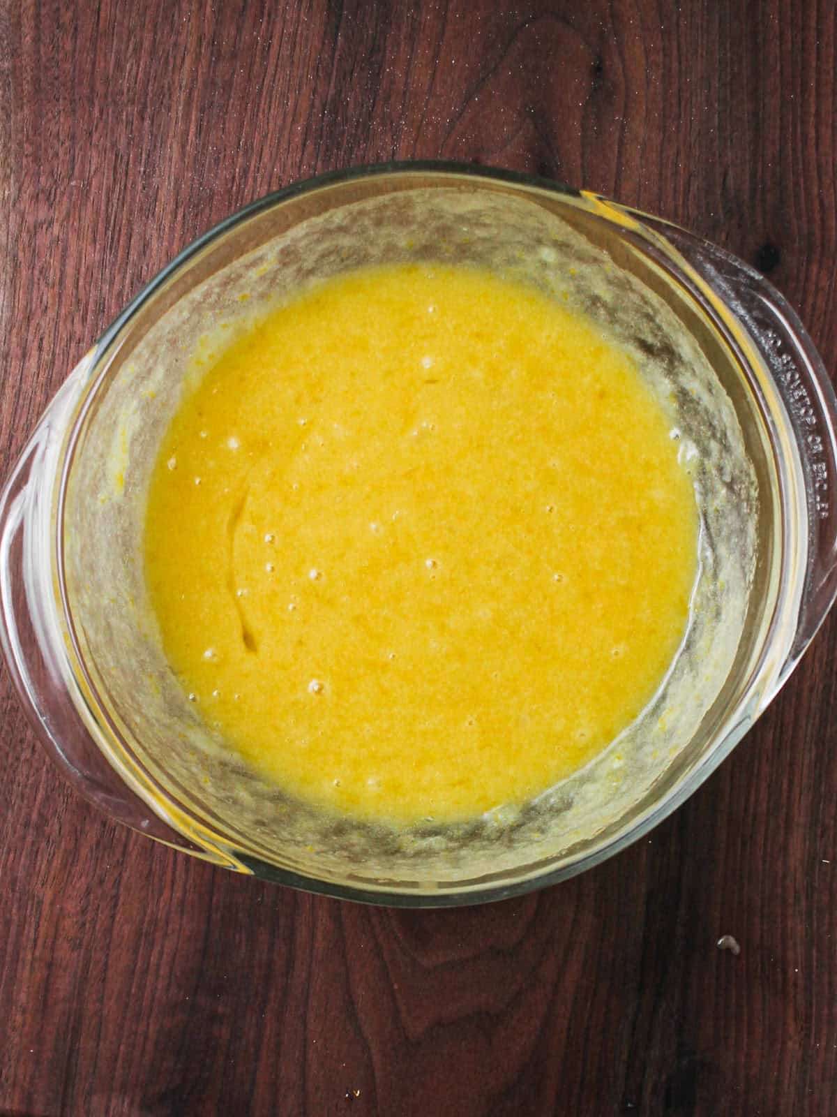 Mixing bowl filled with eggs, oil, and greek yogurt.