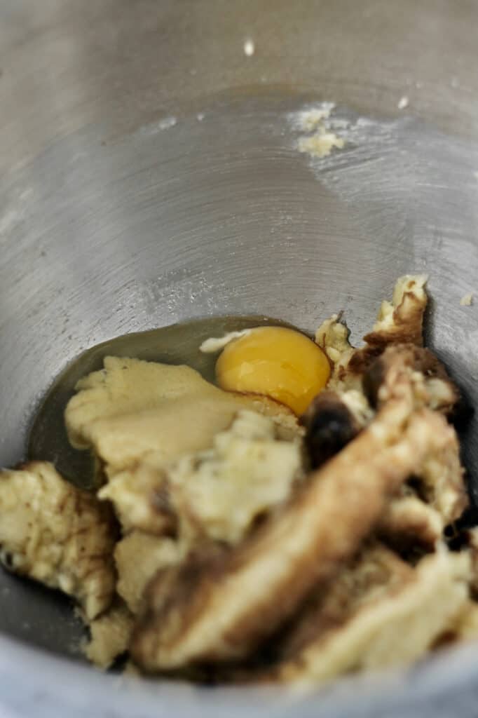 image of creamed sugars and butter, along with egg and mashed banana, in a mixing bowl