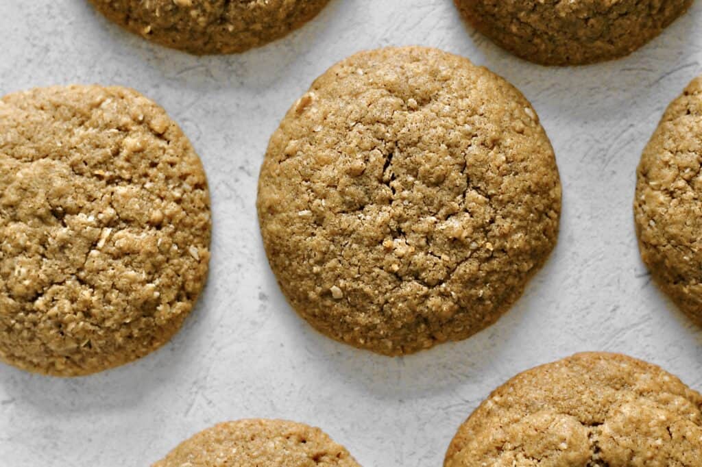 up-close image of a small batch of peanut butter cookies, fully baked and sitting on a grey background