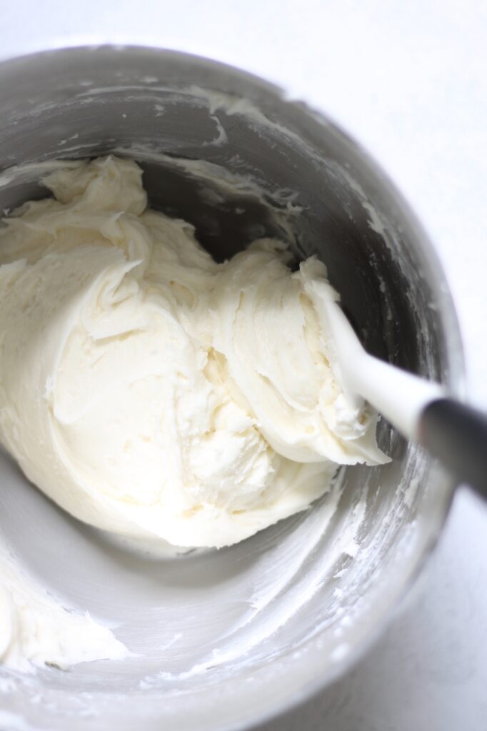 rubber spatula in a bowl of cream cheese frosting