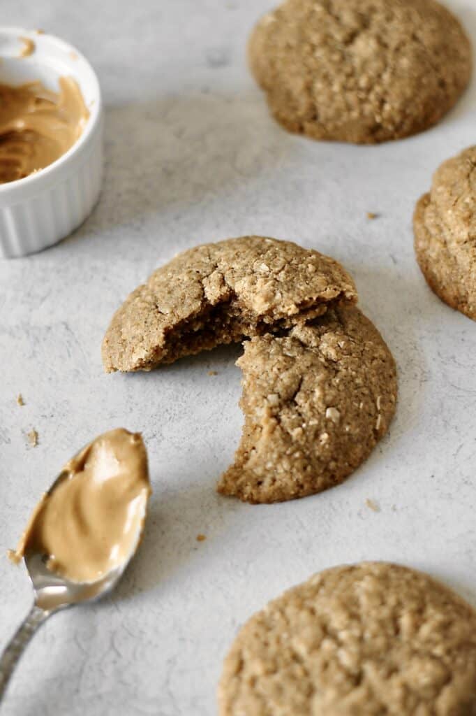 image of peanut butter cookie split in half on a grey background