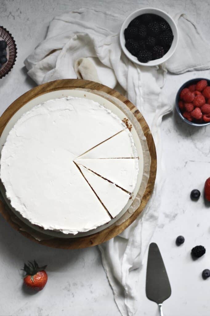 overhead shot of a no bake cheesecake with mascarpone, sitting on a wooden cake stand