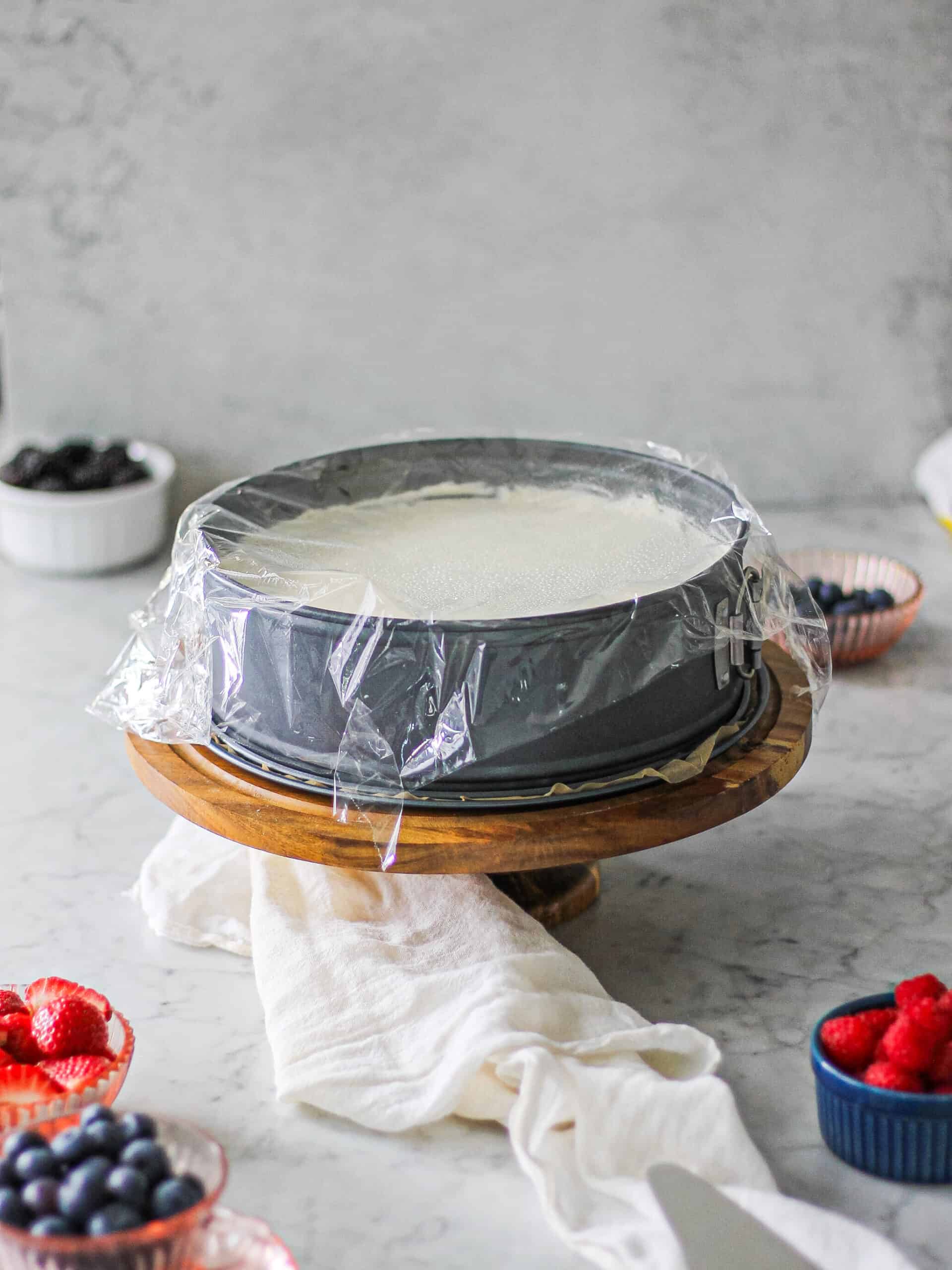 No bake cheesecake with mascarpone once it's sat in the refrigerator for a few hours, now out on the countertop on a brown cake stand.