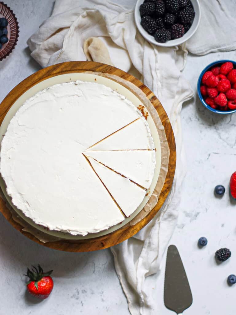 Overhead shot of a no bake cheesecake with mascarpone, sitting on a wooden cake stand.