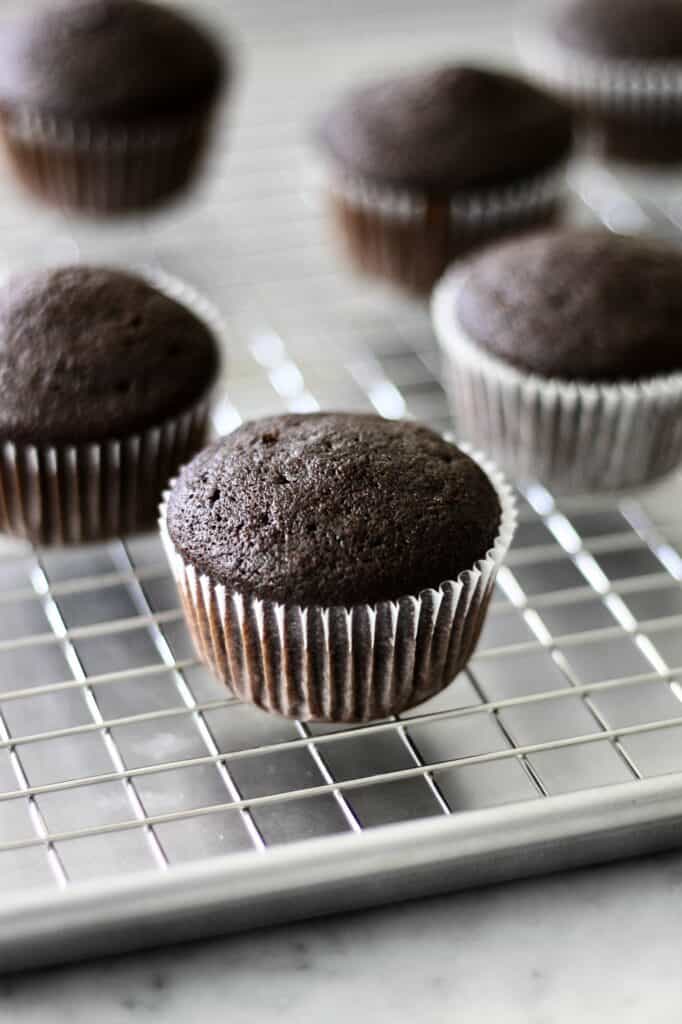 baked chocolate cupcakes sitting on a cooling rack