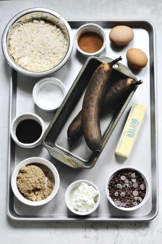 chocolate chip oatmeal banana bread ingredients sitting on a grey aluminum baking pan