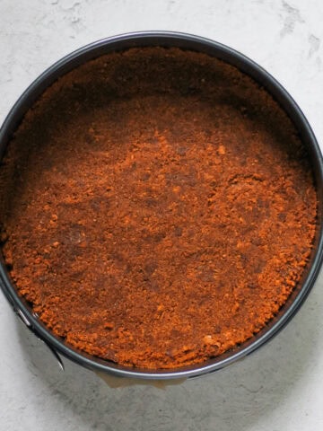 Overhead image of Biscoff Pie Crust pressed into a 9" springform pan on a grey background.
