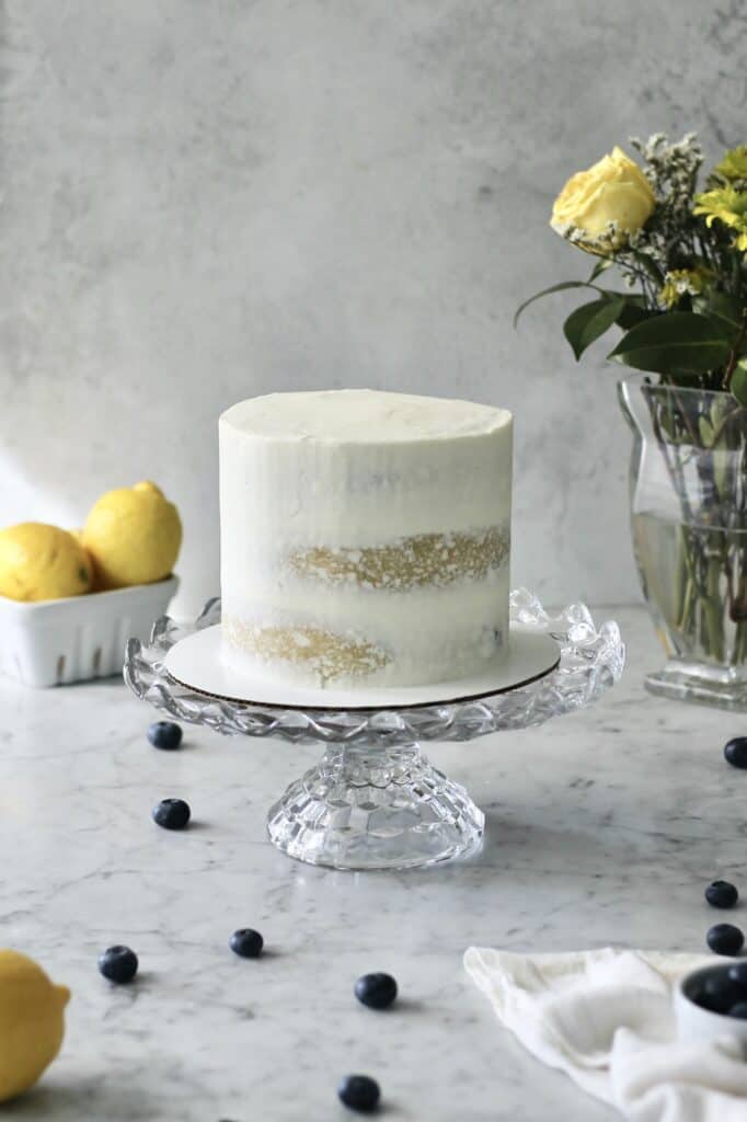 white lemon and blueberry cake on glass cake stand