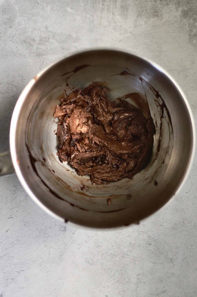 mixing bowl with chocolate frosting ingredients in it