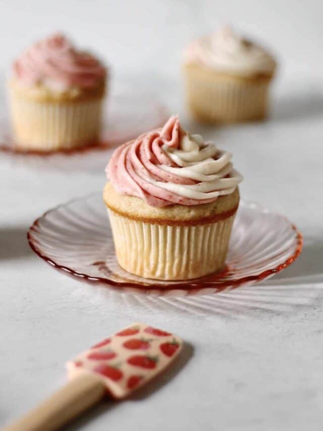 strawberry cupcake sitting on a small pink plate