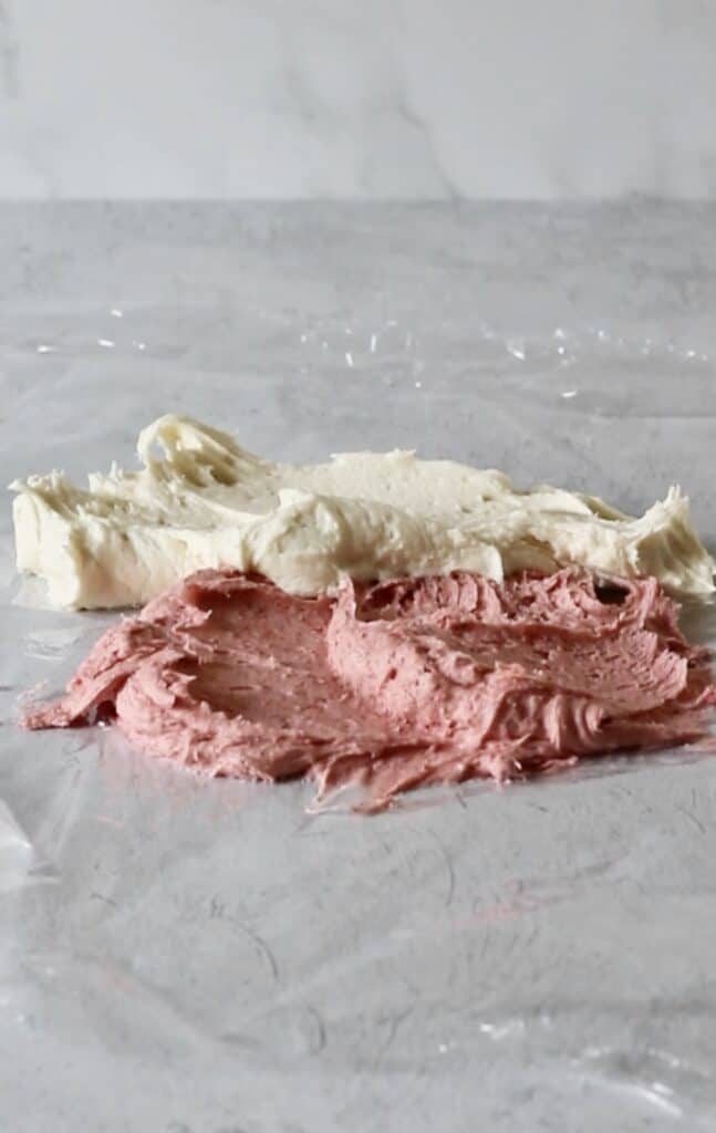 pink strawberry and cream cheese frosting in plastic wrap to make marbled frosting