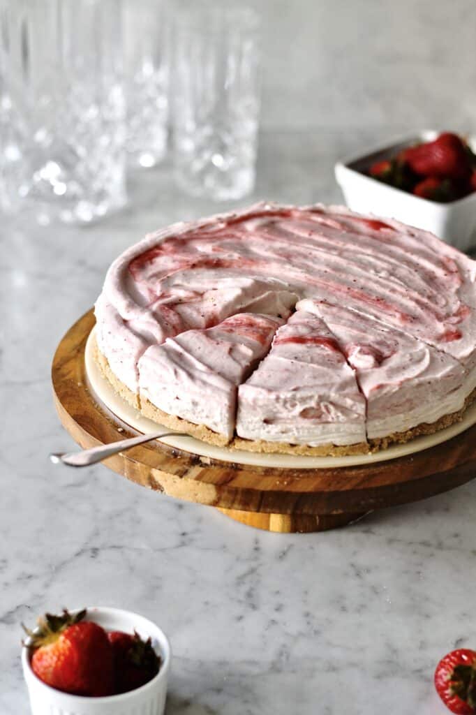 mascarpone strawberry pie, sitting on a brown cake stand with cake server underneath one of three slices