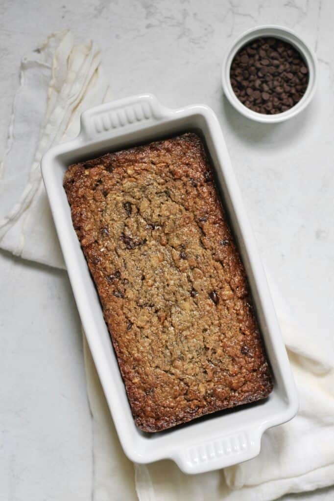 baked banana bread in a white ceramic loaf pan