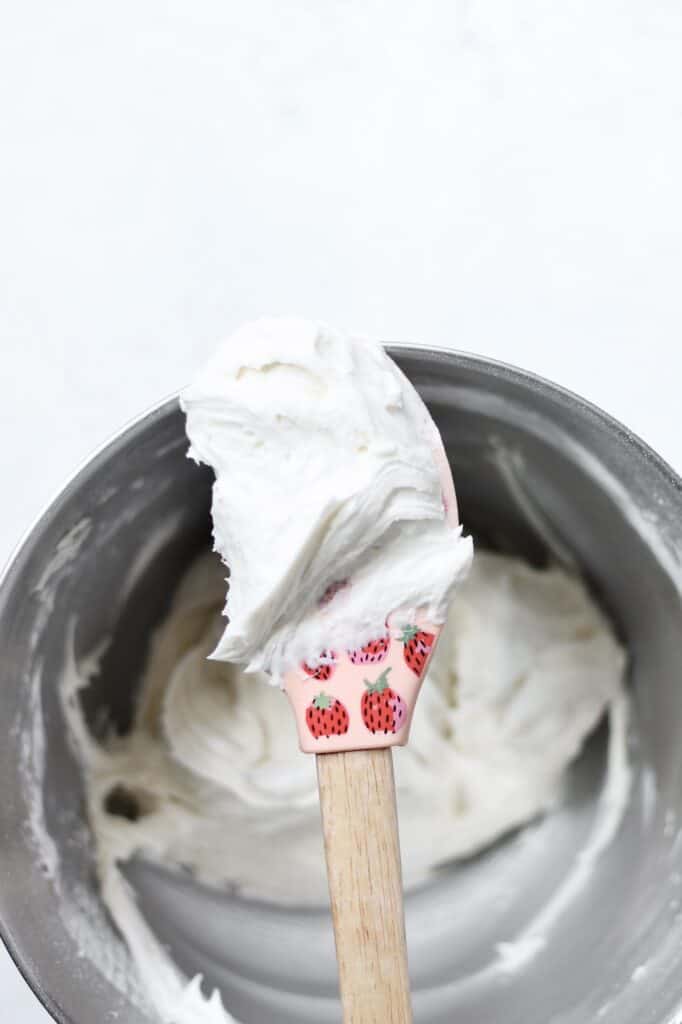 spatula with cream cheese frosting on the end of it