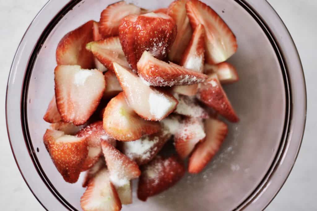 up-close image of strawberries in bowl with sugar on them