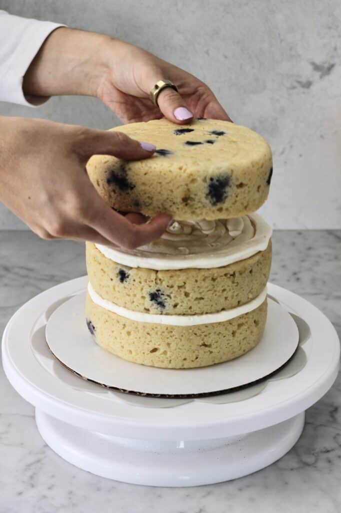 setting third cake layer onto second on a cake turntable