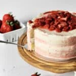 image of pink and white marbled cake, topped with roasted strawberries