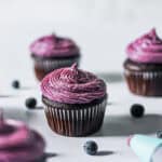 Blueberry cream cheese frosting piped on a chocolate cupcake.