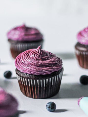 Blueberry cream cheese frosting piped on a chocolate cupcake.