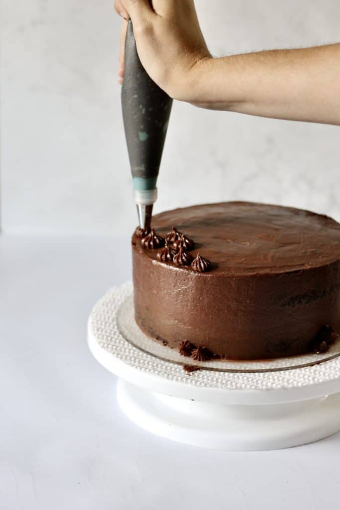 piping detailing on chocolate layer cake
