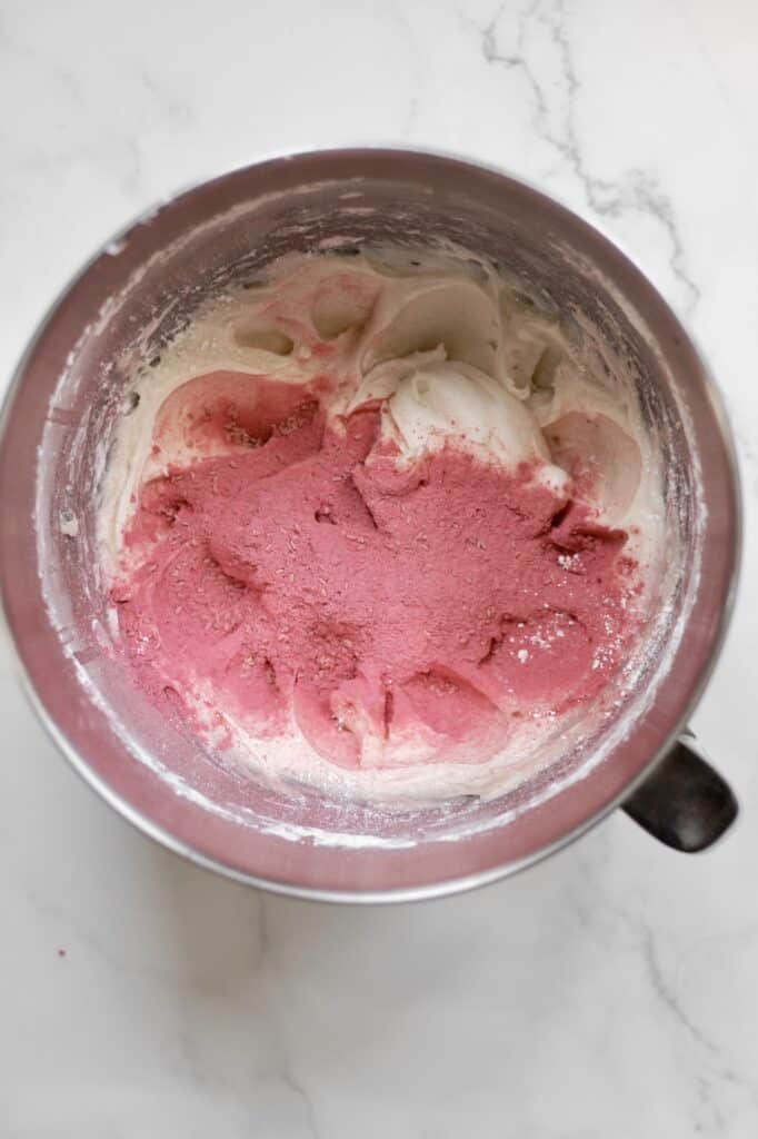 cream cheese frosting in a mixing bowl with ground freeze dried raspberries