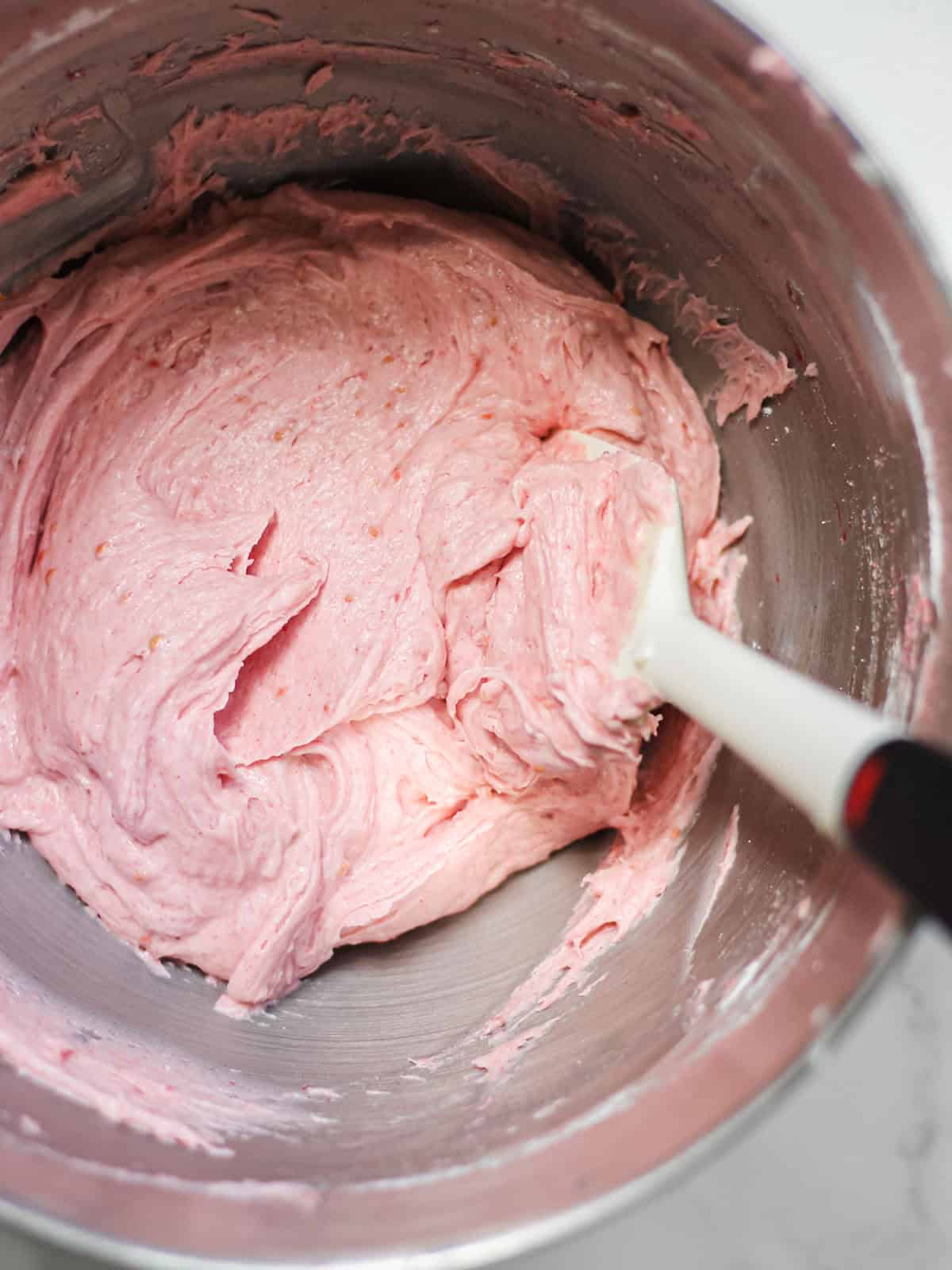 Raspberry cream cheese frosting in a mixing bowl.