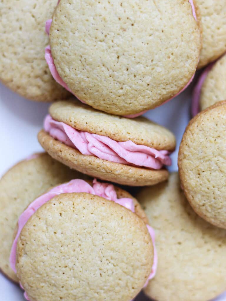 Raspberry cream cheese frosting in between cookie sandwiches.
