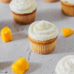 Mango cupcake surrounded by mango chunks.