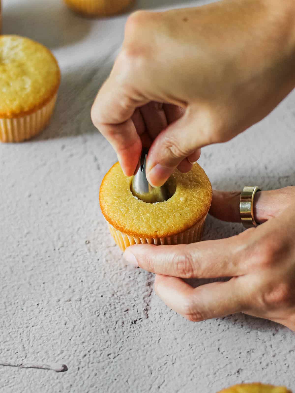 Coring mango cupcake to add filling.